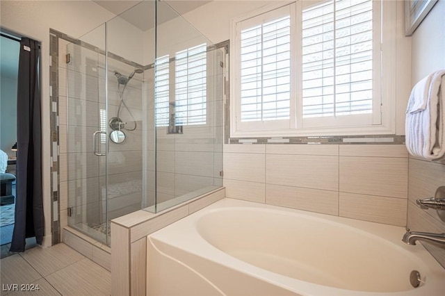 bathroom featuring tile patterned flooring and shower with separate bathtub