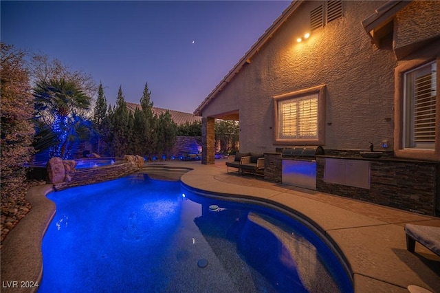 pool at dusk with a patio area, an in ground hot tub, and area for grilling