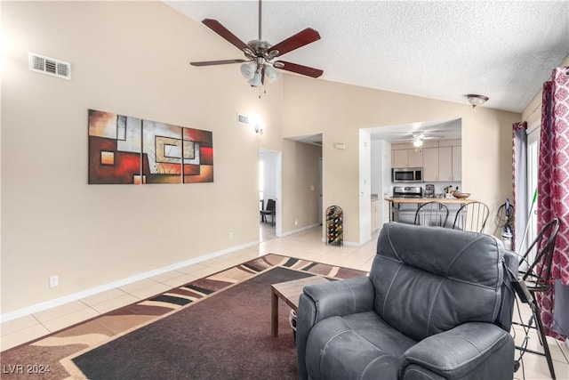 living room featuring ceiling fan, light tile patterned floors, a textured ceiling, and high vaulted ceiling