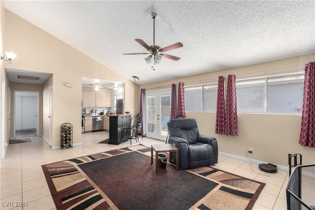 tiled living room featuring ceiling fan, french doors, high vaulted ceiling, and a textured ceiling