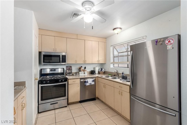 kitchen featuring light tile patterned flooring, light brown cabinetry, stainless steel appliances, and sink