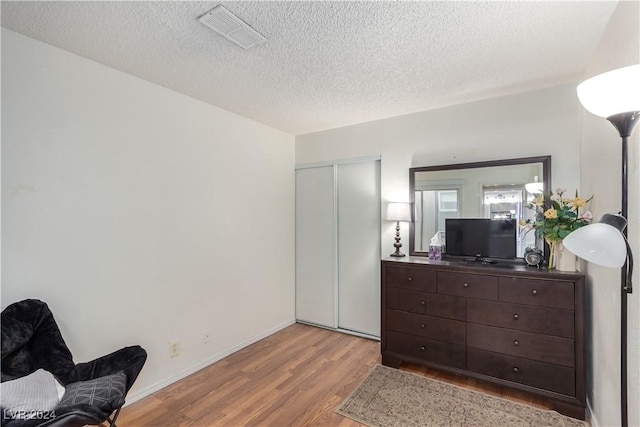 sitting room with a textured ceiling and light hardwood / wood-style flooring