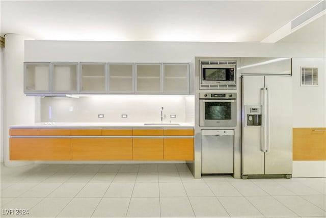 kitchen with sink, light tile patterned flooring, and stainless steel appliances