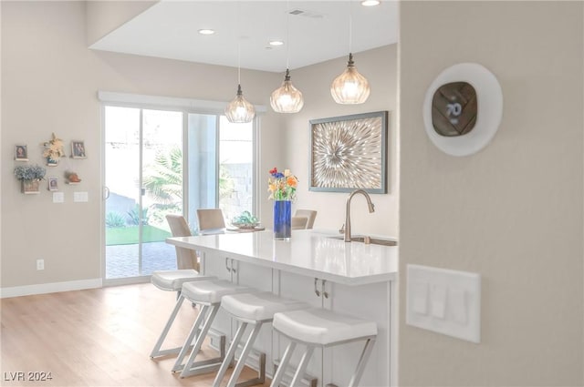 dining space with sink and light hardwood / wood-style floors