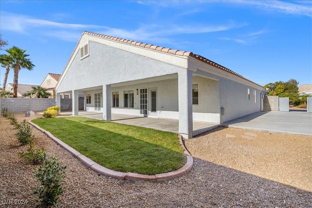 rear view of property with a patio area and a yard