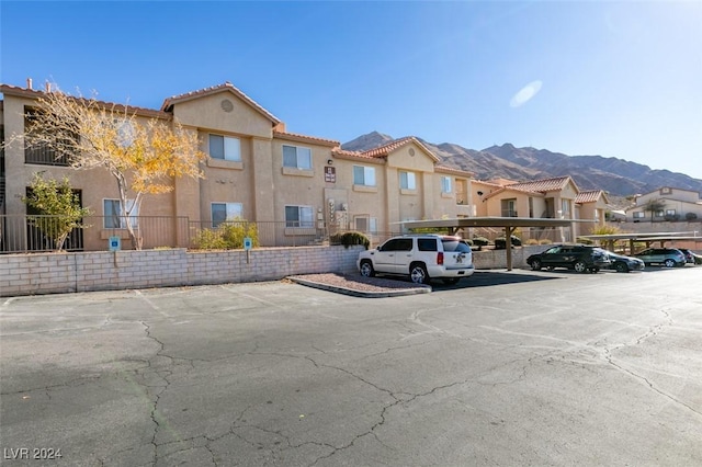 view of parking / parking lot with a carport and a mountain view