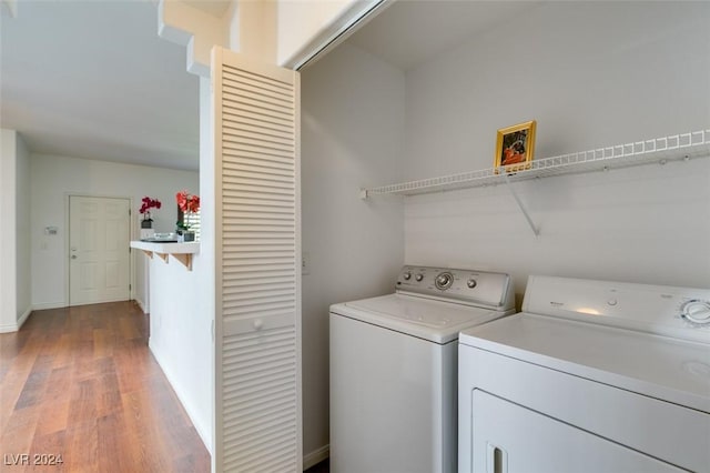 laundry room featuring separate washer and dryer and hardwood / wood-style flooring