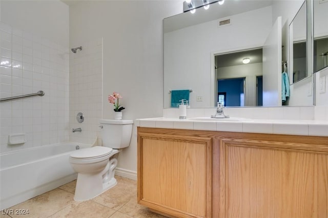 full bathroom featuring tiled shower / bath, vanity, tile patterned floors, and toilet