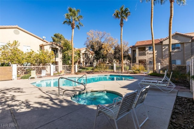 view of swimming pool featuring a hot tub and a patio area