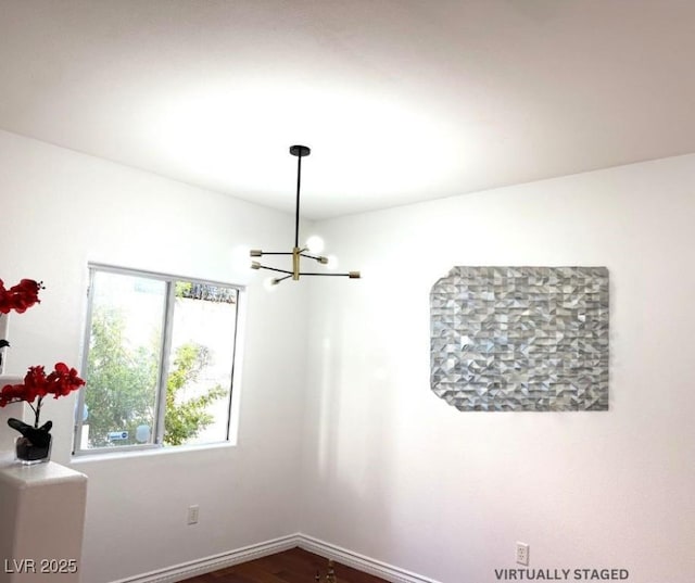 unfurnished room with dark wood-type flooring and a chandelier