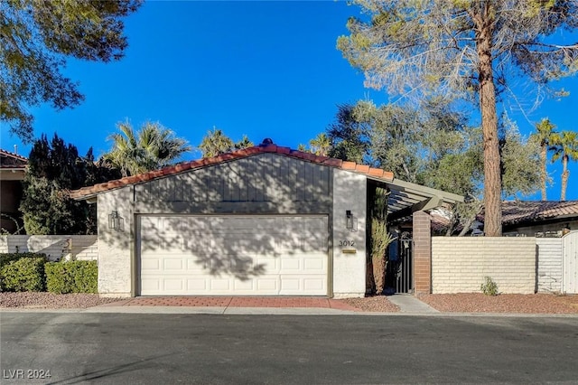 mid-century inspired home featuring stucco siding, driveway, an attached garage, and fence