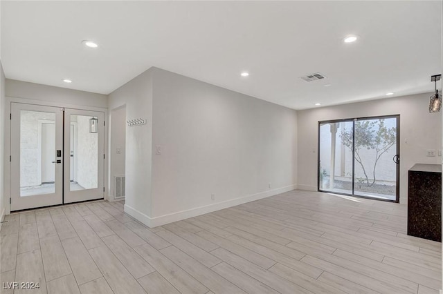 unfurnished living room with french doors and light hardwood / wood-style floors