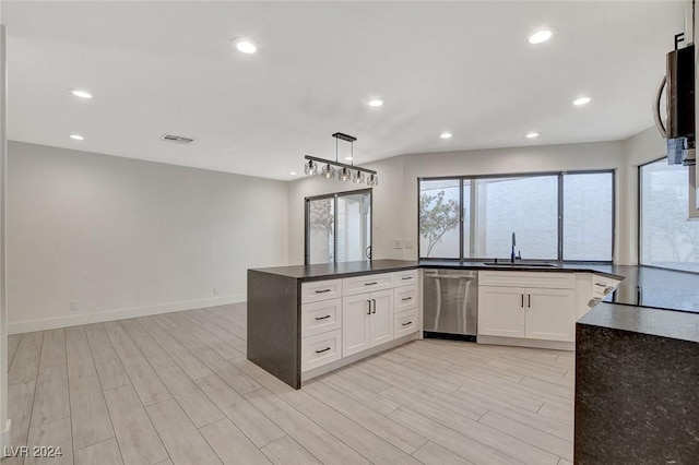 kitchen featuring white cabinets, appliances with stainless steel finishes, hanging light fixtures, and sink