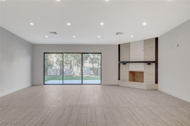 unfurnished living room featuring a stone fireplace