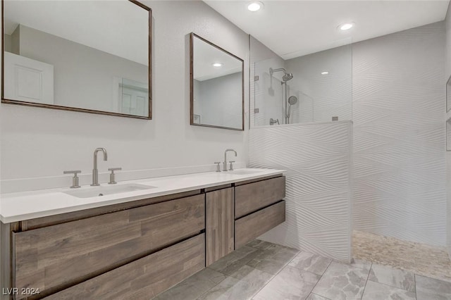 bathroom with a tile shower and vanity