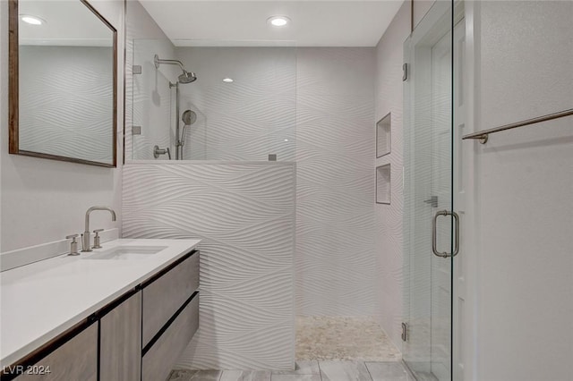 bathroom with a shower with door and vanity