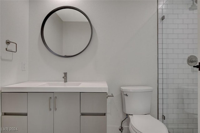 bathroom featuring vanity, toilet, and tiled shower