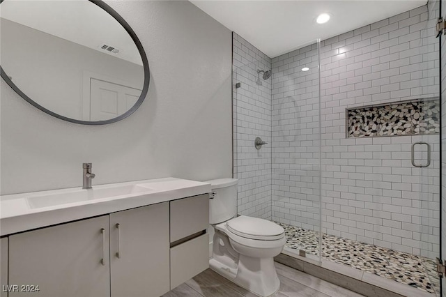 bathroom featuring vanity, toilet, and walk in shower