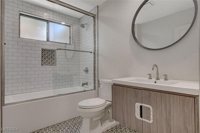 full bathroom with combined bath / shower with glass door, vanity, toilet, and tile patterned flooring