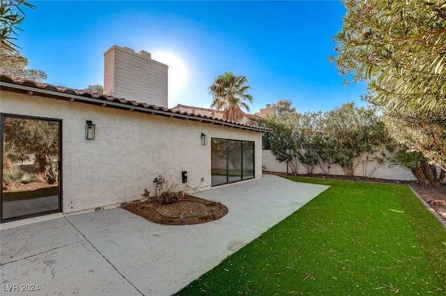 back of house featuring a yard and a patio