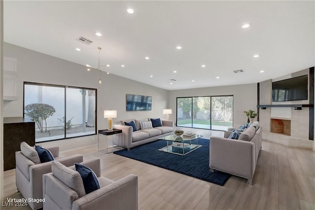 living room featuring a fireplace, light hardwood / wood-style floors, and lofted ceiling