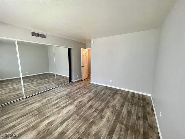 unfurnished bedroom featuring a closet and hardwood / wood-style floors