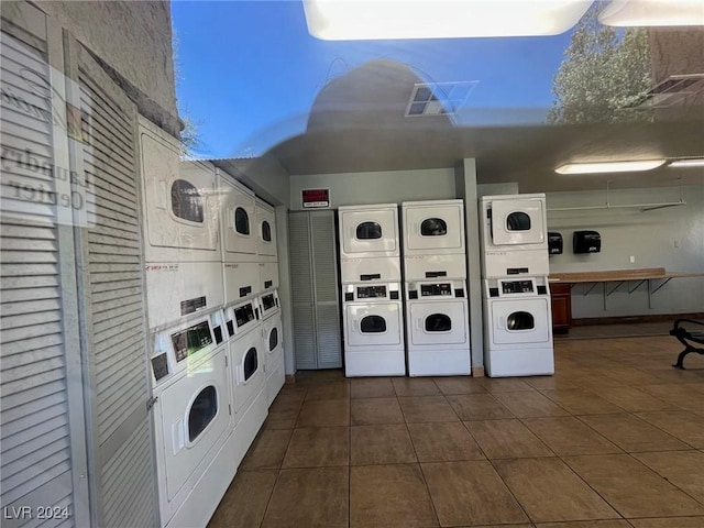 washroom featuring dark tile patterned floors, separate washer and dryer, and stacked washer / dryer