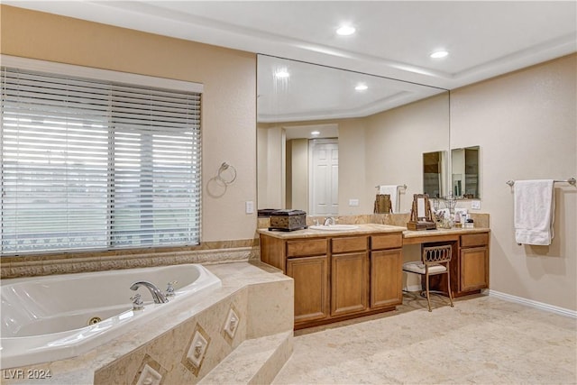 bathroom featuring vanity and a relaxing tiled tub