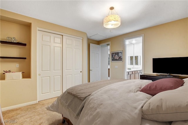 carpeted bedroom featuring ensuite bath and a closet