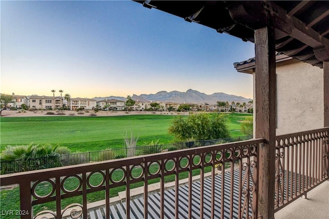 balcony at dusk featuring a mountain view