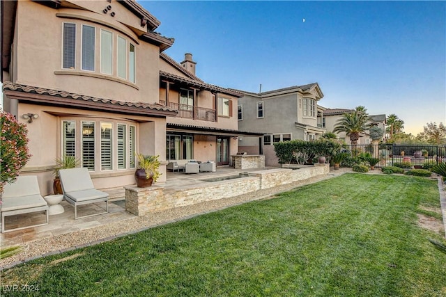 back of property featuring outdoor lounge area, a yard, and a patio