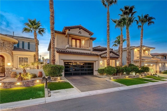 mediterranean / spanish-style home featuring a lawn, a garage, and a balcony