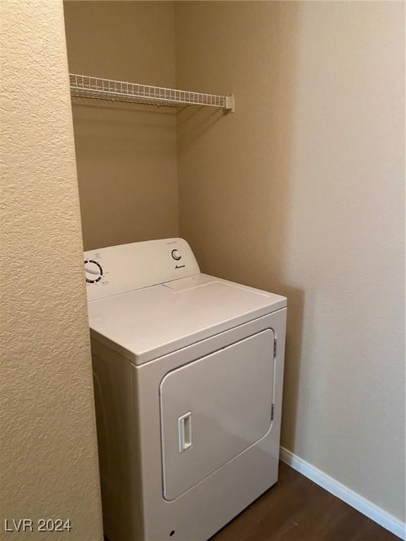 clothes washing area featuring washer / clothes dryer and dark hardwood / wood-style floors