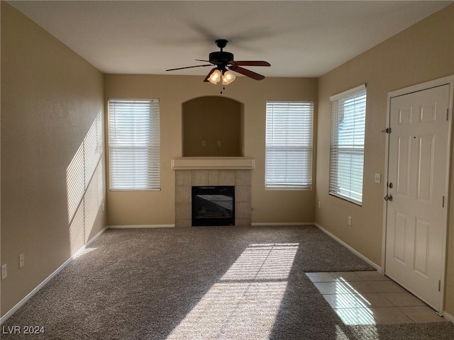 unfurnished living room with ceiling fan, light colored carpet, and a fireplace