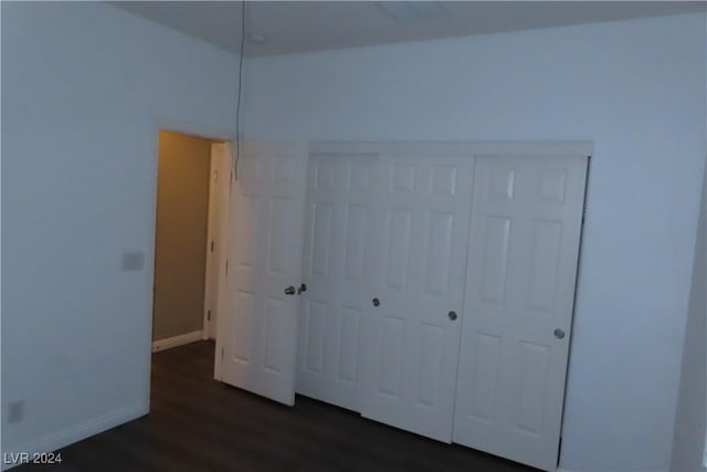 unfurnished bedroom featuring dark hardwood / wood-style flooring and a closet