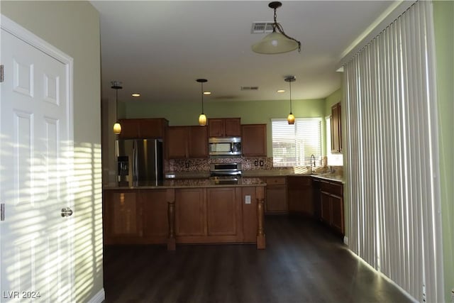 kitchen featuring pendant lighting, sink, stainless steel appliances, dark hardwood / wood-style floors, and tasteful backsplash