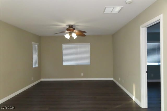 spare room featuring dark wood-type flooring and ceiling fan