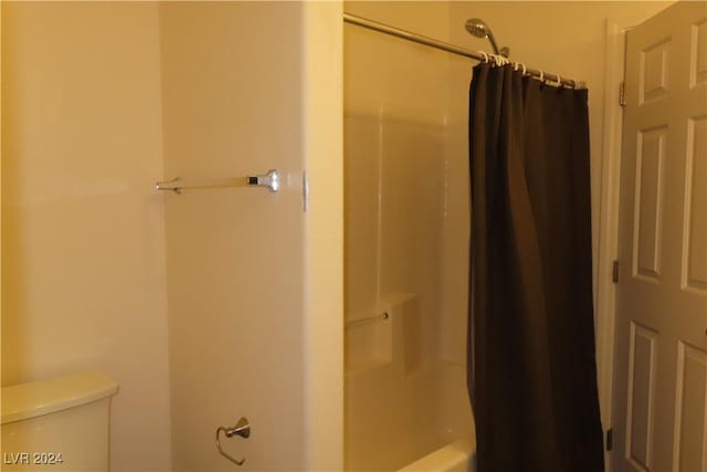 bathroom featuring shower / tub combo with curtain and toilet