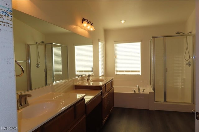 bathroom featuring vanity, hardwood / wood-style floors, and plus walk in shower