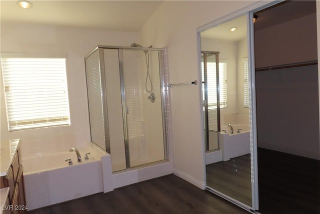 bathroom with wood-type flooring, plus walk in shower, and vanity