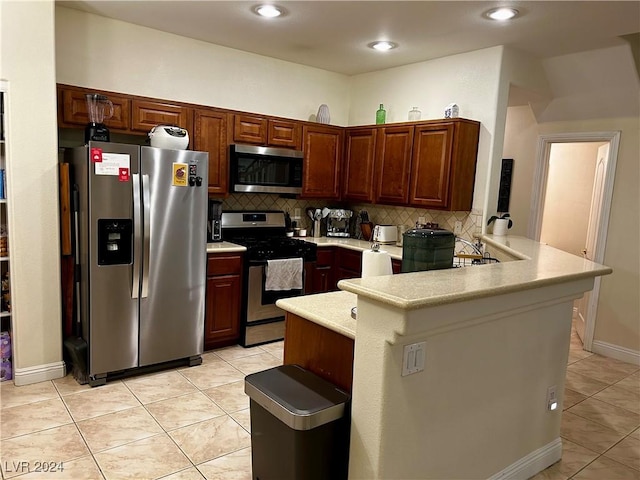 kitchen with kitchen peninsula, decorative backsplash, stainless steel appliances, and light tile patterned floors