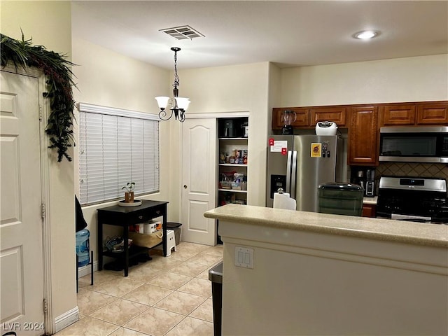 kitchen with decorative light fixtures, light tile patterned flooring, appliances with stainless steel finishes, and a chandelier