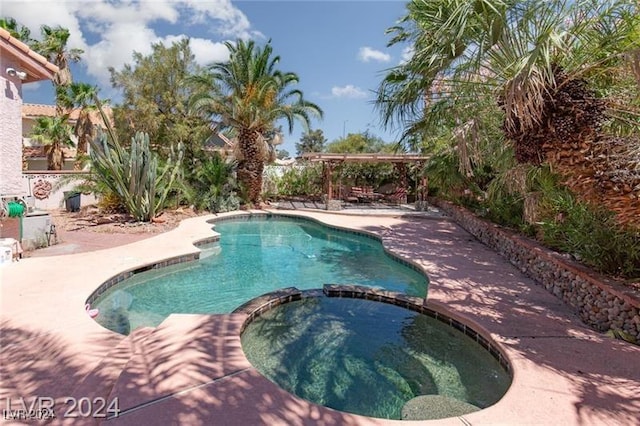 view of swimming pool featuring a patio area and an in ground hot tub