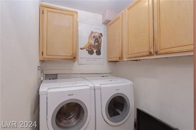 laundry area with washer and dryer and cabinets