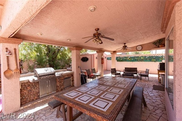 view of patio featuring outdoor lounge area, a grill, ceiling fan, and an outdoor kitchen