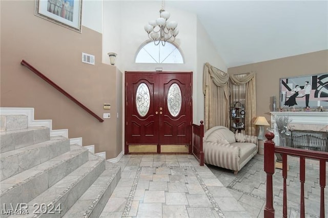 foyer with high vaulted ceiling and a chandelier