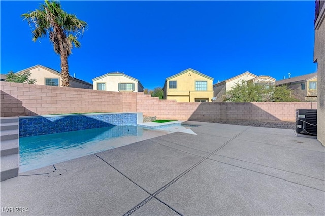 view of swimming pool with central air condition unit and a patio