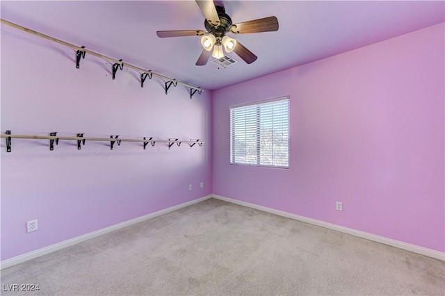 carpeted spare room with ceiling fan