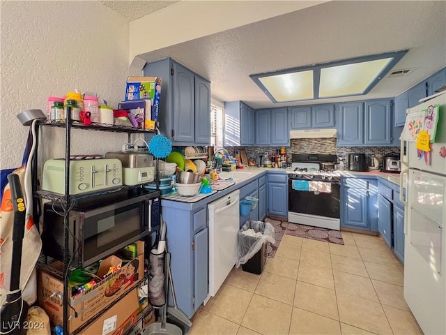 kitchen with light tile patterned floors, white appliances, blue cabinets, and sink