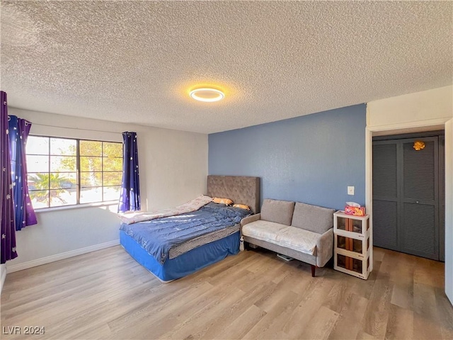 bedroom featuring hardwood / wood-style floors and a textured ceiling